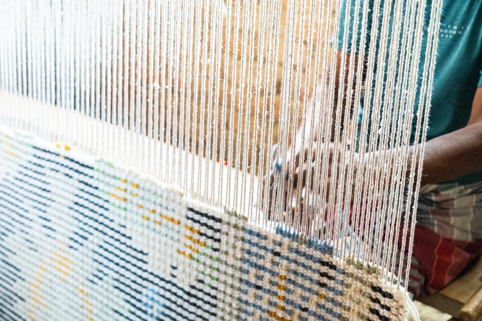 Close detail of a rug being woven on the loom.